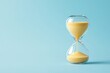 © Archibalttttt - A clean, minimalist image of an hourglass set against a light blue background, symbolizing the passage of time and simplicity
