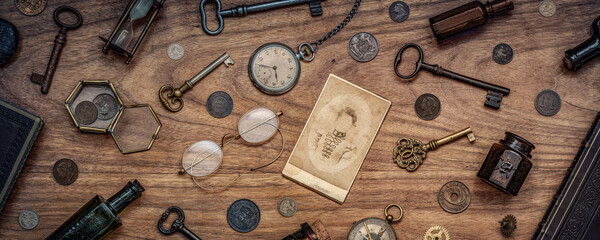 Wall Mural - A collection of antique antiques is spread out on the table. Old coins, glasses, photography, glass bottles, keys, watch and compass. Vintage collection. History  background.