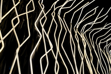 Aufkleber - Modern lighting installation featuring intertwined white light tubes against dark background. Contemporary design, architectural lighting and creative illumination projects
