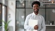 © KKC Studio - Confident Young Professional in Modern Urban Office Setting with Clear Space for Text, Holding Folder While Looking Out the Window