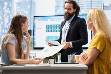 Poster - financial advisor presents detailed stock market analysis to clients on big screen, helping them mak