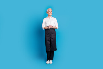 Wall Mural - Full size photo of retired female barista small coffee shop owner look empty space wear waitress uniform isolated on blue color background