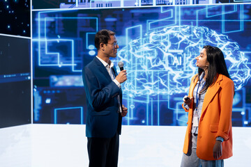Poster - Speaker interviewing guest during presentation, exploring ways emerging AI technologies can enhance businesses. IT company colleagues at event present artificial intelligence tech
