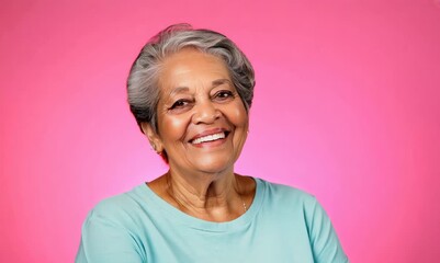 Wall Mural - smiling senior woman in t-shirt looking at camera isolated on pink