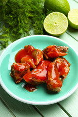 Wall Mural - Plate with canned fish in tomato sauce, lime and dill on green wooden table