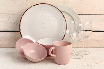 Wall Mural - Set of different dishes on table near beige wooden wall