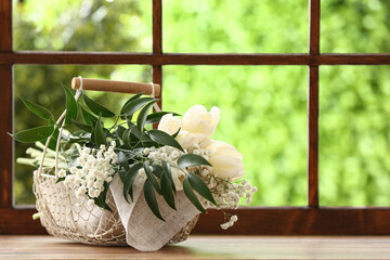 Wall Mural - Basket with beautiful tulip and gypsophila flowers on windowsill