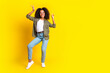© deagreez - Full size photo of carefree nice girl dressed khaki jacket jeans pants dancing near empty space isolated on yellow color background