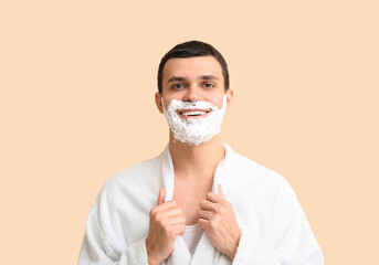 Canvas Print - Handsome young man with shaving foam on his face against beige background