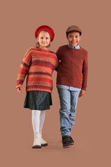 Poster - Cute little happy kids in warm clothes on brown background