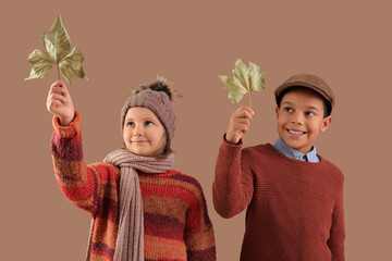 Sticker - Cute little happy kids in warm clothes with autumn leaves on brown background