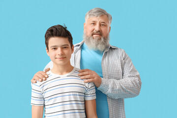 Wall Mural - Happy grandfather with his cute grandson on blue background