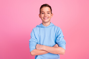 Photo portrait of cute teen boy crossed hands confident dressed stylish blue clothes isolated on pink color background