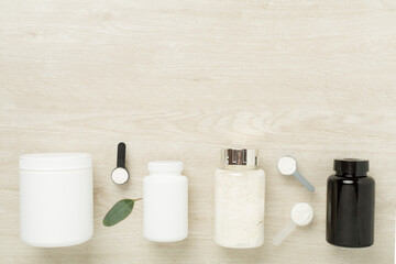 Sticker - Jars with protein powder on wooden background, top view. Sports nutrition concept