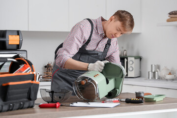 Poster - Male technician repairing coffee machine in kitchen