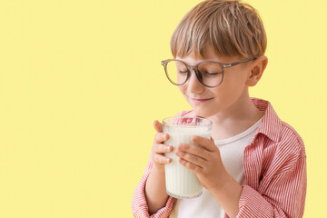 Sticker - Cute little boy with glass of milk on yellow background