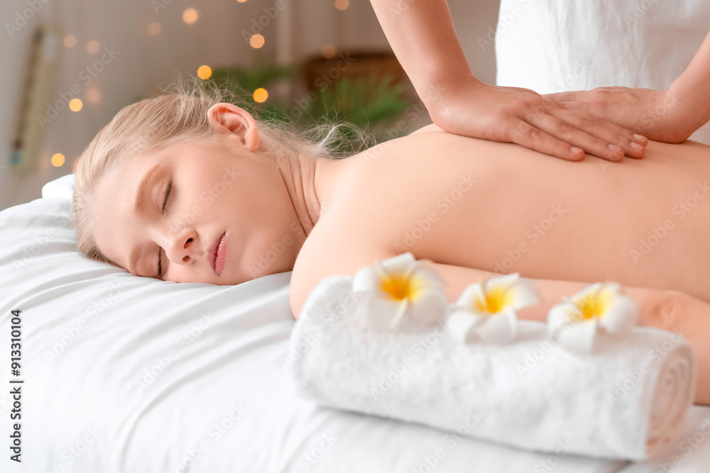 Young woman enjoying massage in spa salon