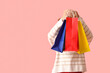 © Pixel-Shot - Young woman with shopping bags on pink background