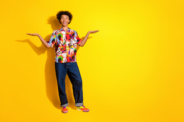 Poster - Full size photo of nice young man hold empty space vs wear shirt isolated on bright yellow color background