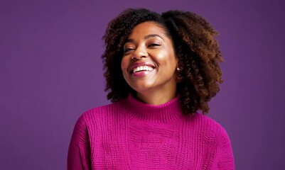 Wall Mural - smiling african american woman in pink sweater over purple background