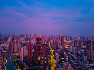 Aerial view of modern city skyline and burning clouds at sunrise in Shanghai.