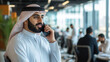 © Hound - An Emirati man in his mid thirties, wearing a white long sleeve kandura with black and grey keffiyeh is talking on the phone inside an office building