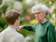 © pprothien - In a lush garden, an elderly woman scolds a young boy, pointing her finger in a disapproving manner.