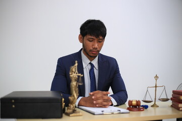 Asian male lawyer reading time limit law, giving advice, tax office, law firm, judge, legal advisor, lawyer working in office, judge knocking wood with lawyer for justice, contract