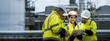 © Dee karen - Male and female industrial engineers wearing hard hats talk to collaborate on new project. Team of engineers inspecting gas separation plant using tablets.