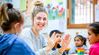 © KamokamoZa - Happy female teacher assisting her student during a class at elementary school.