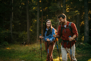 Wall Mural - Shot of a happy young couple going for a romantic walk in the woods