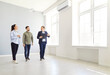 © Studio Romantic - Professional mature real estate male agent showing new apartment to young couple. Man and woman talking with man realtor in new house and ready to become homeowners. Real estate market concept.