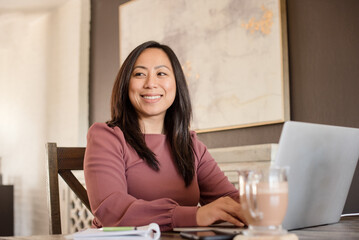 smiling woman on laptop at home working