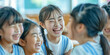 © Aigo labs - A group of young school girls laughing together in a classroom, radiating pure joy and friendship.