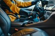 © Olsek - Professional car interior cleaning in progress, close-up view. A worker cleaning vehicle seats with a vacuum cleaner. Ideal for automotive cleaning services and maintenance themes. AI