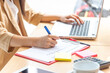 © tonjung - Women Freelance work on computer pointing with color pen electronic gadgets dropped around on table