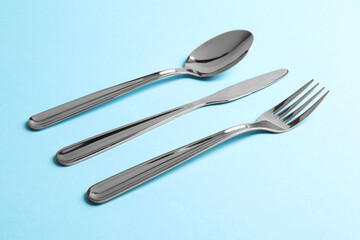 Wall Mural - Stylish silver cutlery on light blue background