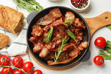 Wall Mural - Delicious bacon slices in frying pan, spices and tomatoes on white table, flat lay