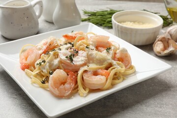 Wall Mural - Delicious pasta with shrimps served on light table, closeup