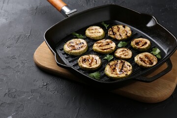 Wall Mural - Tasty grilled zucchini slices with parsley in frying pan on grey textured table