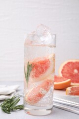 Wall Mural - Refreshing water with grapefruit and rosemary in glass on light table