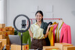 © David - Beautiful sme woman describe selling clothes on camera live broadcast on social network at home, Online selling clothes on social media. Vlogger woman influencer, SME retail store owner.