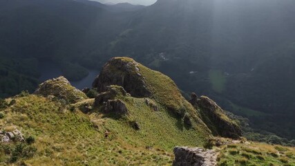 Wall Mural - Caucasian man running at the basque peak Kopakarri under a beautiful sun light.