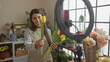 © Krakenimages.com - Hispanic woman records a floral arrangement tutorial in a cozy home interior, showcasing her attractive smile and hobbyist passion.