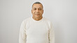 © Krakenimages.com - Mature hispanic man in a white sweater posing against an isolated white background, exuding confidence and approachability.
