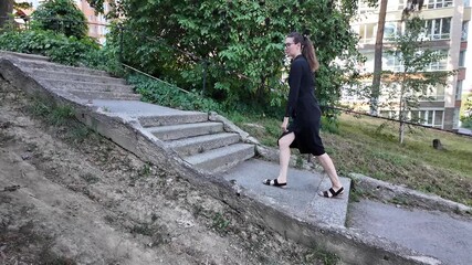 Wall Mural - Woman walking in the city wearing elegant black dress