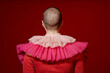 © Seventyfour - Minimal back view of young woman with buzzcut wearing elaborate red dress with ruffles copy space