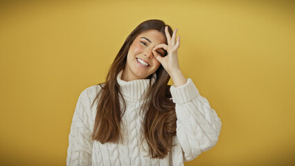 Poster - A joyful young woman makes an okay gesture with her hand against a vibrant yellow background.