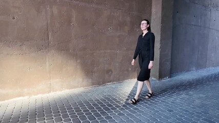 Wall Mural - Woman walking in the city wearing elegant black dress