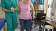 © Krakenimages.com - A man therapist assists a woman patient in walking rehabilitation inside a physiotherapy clinic.